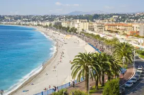 Spiaggia di Nizza, un luogo ideale per pensare a come trovare lavoro all'estero, con palme e mare azzurro.